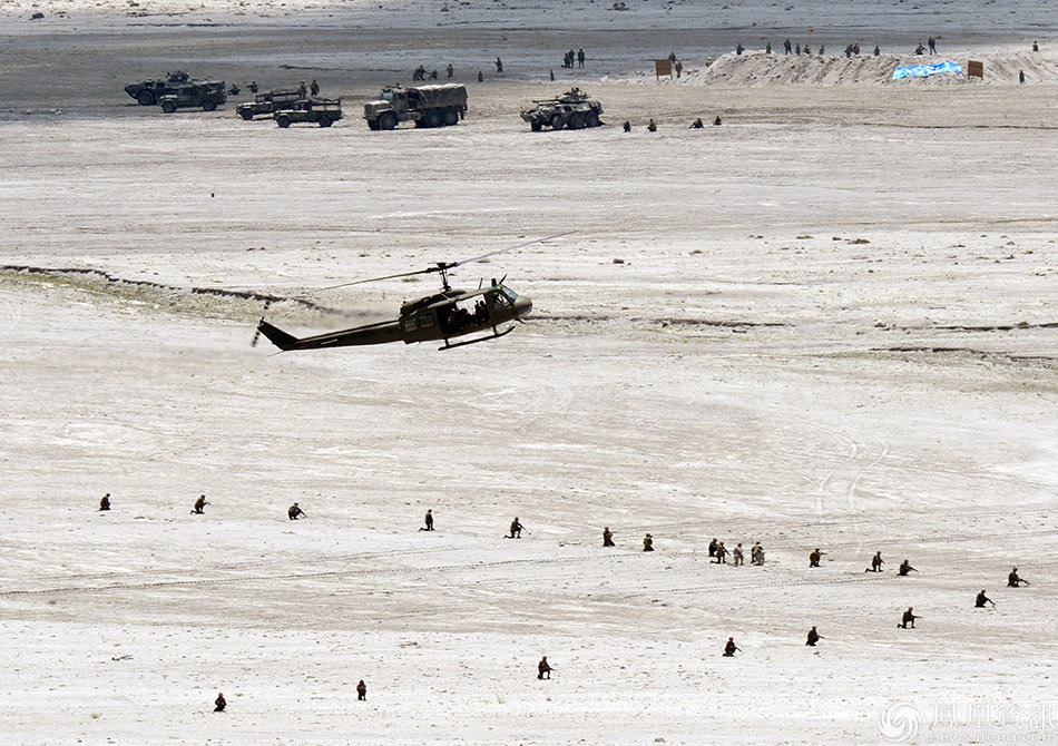 A Philippine Huey helicopter prepares to drop off troops while Philippine marines take positions in an assault simulation during live fire drills on the last day of the annual US-Philippine joint military exercise at the former US traget range in Crow Valley, Capas town, north of Manila on May 15, 2014. US aircraft dropped bombs and marines tore forward under artillery fire in war games in the Philippines on May 15, weeks after the allies signed a defence deal against a backdrop of flaring Chinese tensions with its neighbours. AFP PHOTO