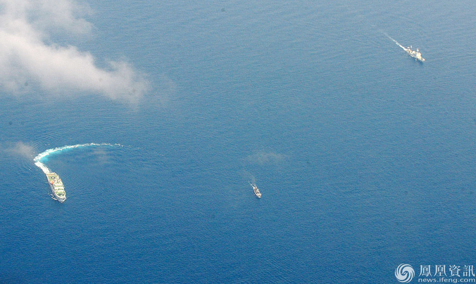 China Coast Guard ships (L and R) and a Philippine supply boat (C) engage in a stand off as the Philippine boat attempts to reach the Second Thomas Shoal, a remote South China Sea a reef claimed by both countries, on March 29, 2014. The Philippine ship finally slipped past the Chinese blockade to reach Second Thomas Shoal, where a handful of Filipino marines are stationed on a Navy vessel that has been grounded there since 1999 to assert their nation's sovereignty. AFP PHOTO / Jay DIRECTO