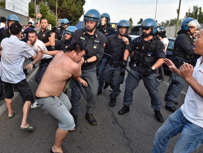 Un momento degli scontri tra forze dell'ordine e circa 300 cinesi radunatisi in n piazza Marconi all'Osmannoro, nel comune di Sesto Fiorentino (Firenze),  in seguito a un controllo in un capannone per eseguire un arresto, Sesto Fiorentino (Firenze), 29 Giugno 2016. ANSA/ MAURIZIO DEGL'INNOCENTI