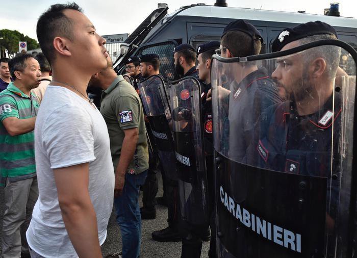 Un momento degli scontri tra forze dell'ordine e circa 300 cinesi radunatisi in n piazza Marconi all'Osmannoro, nel comune di Sesto Fiorentino (Firenze),  in seguito a un controllo in un capannone per eseguire un arresto, Sesto Fiorentino (Firenze), 29 Giugno 2016. ANSA/ MAURIZIO DEGL'INNOCENTI