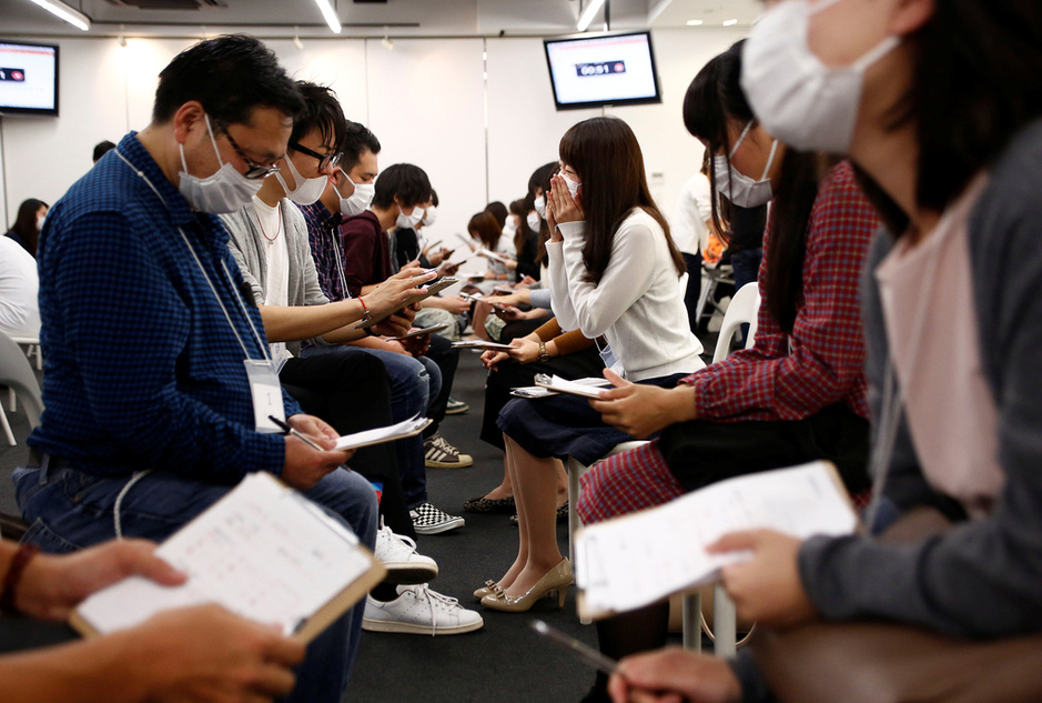 Participants wearing surgical masks talk to each other during a masked match-making event in Tokyo, Japan, October 16, 2016. Picture taken on October 16, 2016.  REUTERS/Kim Kyung-Hoon