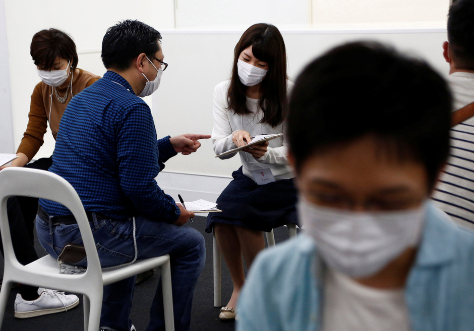 Participants wearing surgical masks talk to each other during a masked match-making event in Tokyo, Japan, October 16, 2016. Picture taken on October 16, 2016.  REUTERS/Kim Kyung-Hoon