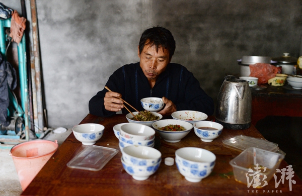 2016年11月17日，江西吉安永丰县石马镇严辉村，范家发在吃早饭，通常他是家中最后一个吃早饭的。 范家发把拐杖放下，一屁股坐在板凳上点了一支烟，默默地吐着烟雾。在9岁的儿子范小勤因与马云撞脸走红后，他几乎就没有闲下来的时间，原来家中洗衣做饭接送孩子及下地干农活一件也不能少干，现在还要接待纷至沓来的访客。范家发的家所在地，一个位于江西吉安永丰县石马镇的僻壤乡村，也因为他儿子的走红打破了往昔的平静。 范家发今年59岁了，在20多岁时被毒蛇咬伤无奈截肢了右腿，独腿的他娶了患有小儿麻痹症致智力障碍的妻子，生下了大儿子范小勇和二儿子范小勤，家中一贫如洗，依靠低保过活。更为不幸的是，范家发80多岁的妈妈又患上了老年痴呆。 一条腿的范家发几乎一人承担了家中所有的家务，还要打零工挣钱养活家人。妻子除了放放牛，帮忙挑挑东西之外几乎什么活都不会干。范家发一早起来要烧火做饭，给孩子洗脸换衣服，然后骑上三轮车送孩子们去上学。返回后，督促妻子牵牛到山上去吃草，范家发把早饭用过的碗筷、孩子昨夜换下的衣服和鞋子都一一洗掉。中午放学时间范家发又得去接孩子回来吃午饭，吃好再送回学校去上下午的课。而下午通常他会带着妻子到地里去干农活，日子一成不变。这个每日为生计操劳奔波的农民，怎么也想不到自己的二儿子范小勤会成为网红，并且红得有点惊人。 文字未完整 早报见习记者 赖鑫琳 图